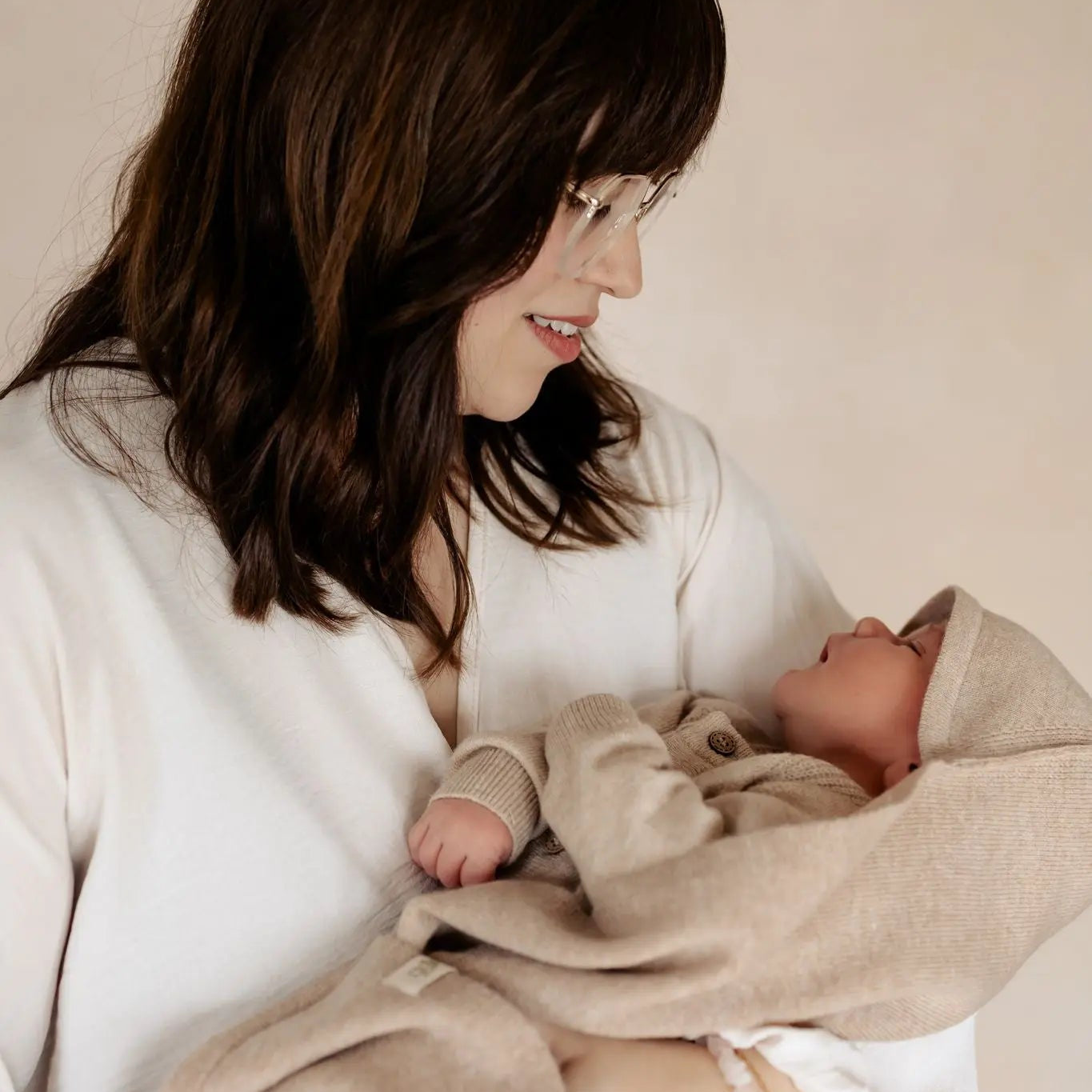 Moeder houdt haar pasgeboren baby vast in een zachte merinowollen 3-in-1 babydeken van Moalie