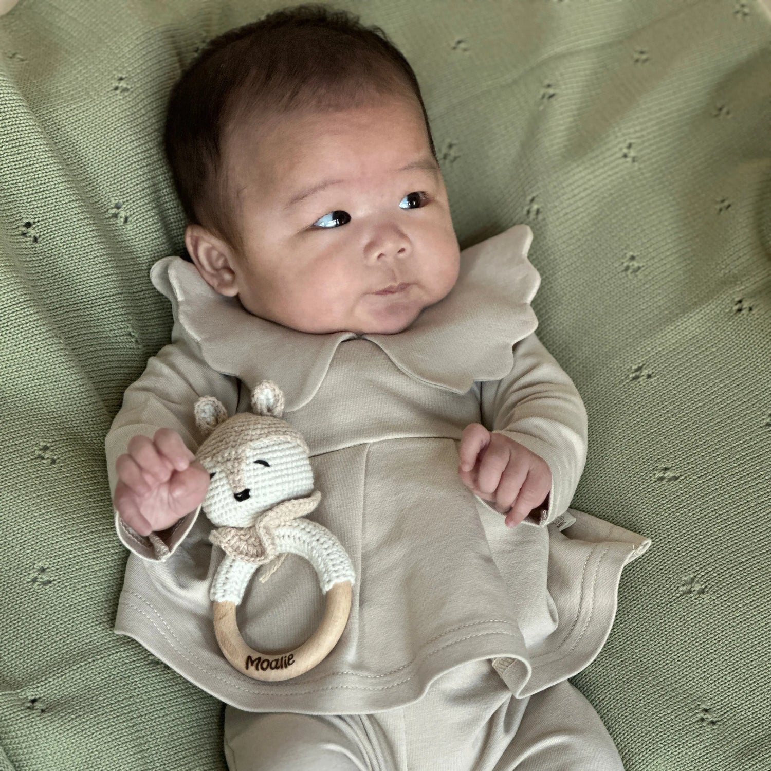 Baby met handgemaakte rammelaar in de vorm van een vos – gehaakt van biologisch katoen met houten bijtring