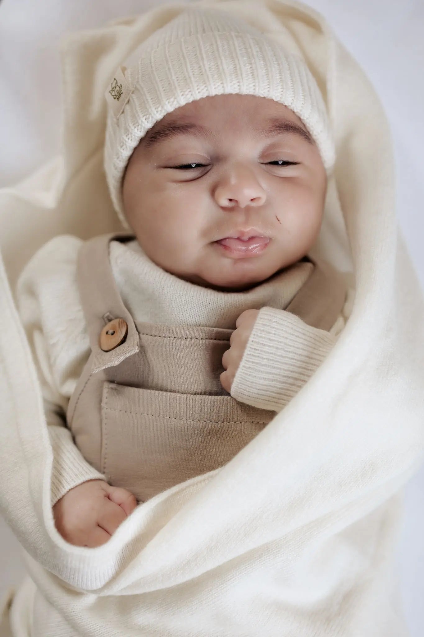 Newborn baby in Moalie outfit en mutsje van Merinowol en Cashmere in Creme kleur