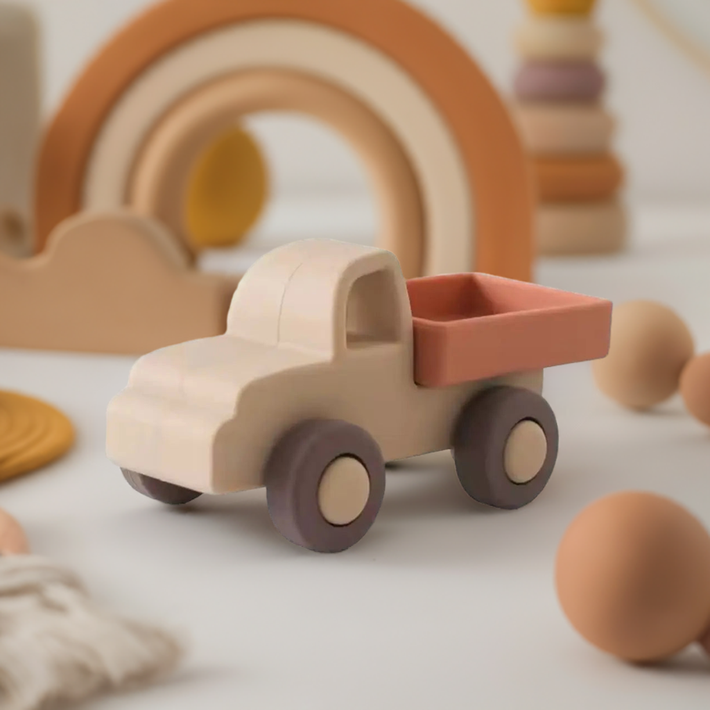 een speelgoed vrachtwagen van siliconen geplaatst op een vlakke ondergrond met ander speelgoed