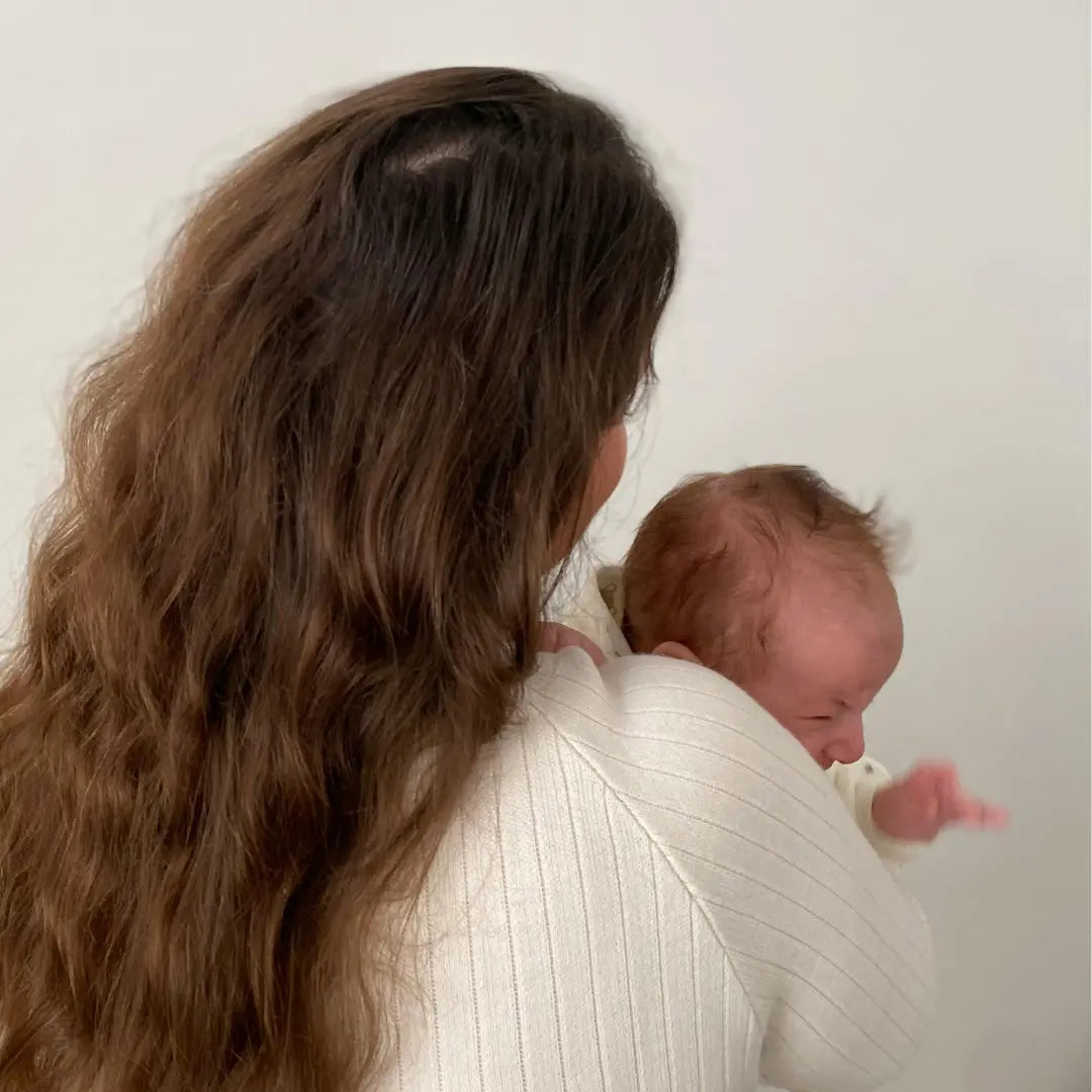 Huilende baby in armen van moeder