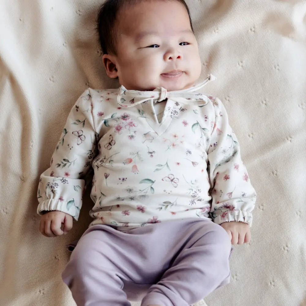 meisjes baby in lila broekje en gebloemd truitje 