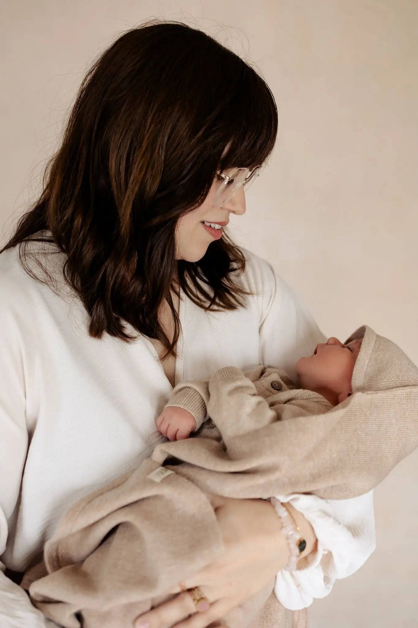 Mutter hält ihr Neugeborenes in einer weichen 3-in-1-Babydecke aus Merinowolle von Moalie