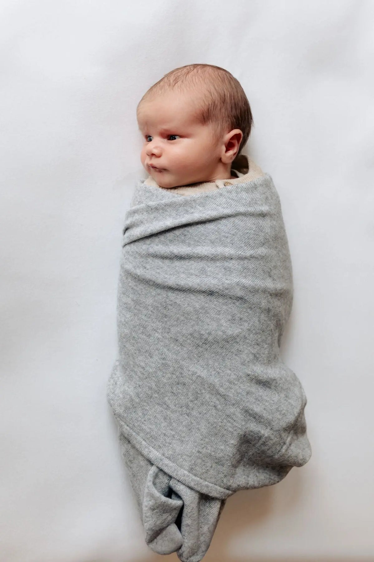 baby gewikkeld in grijze merinowol en cashmere omslagdoek van Moalie