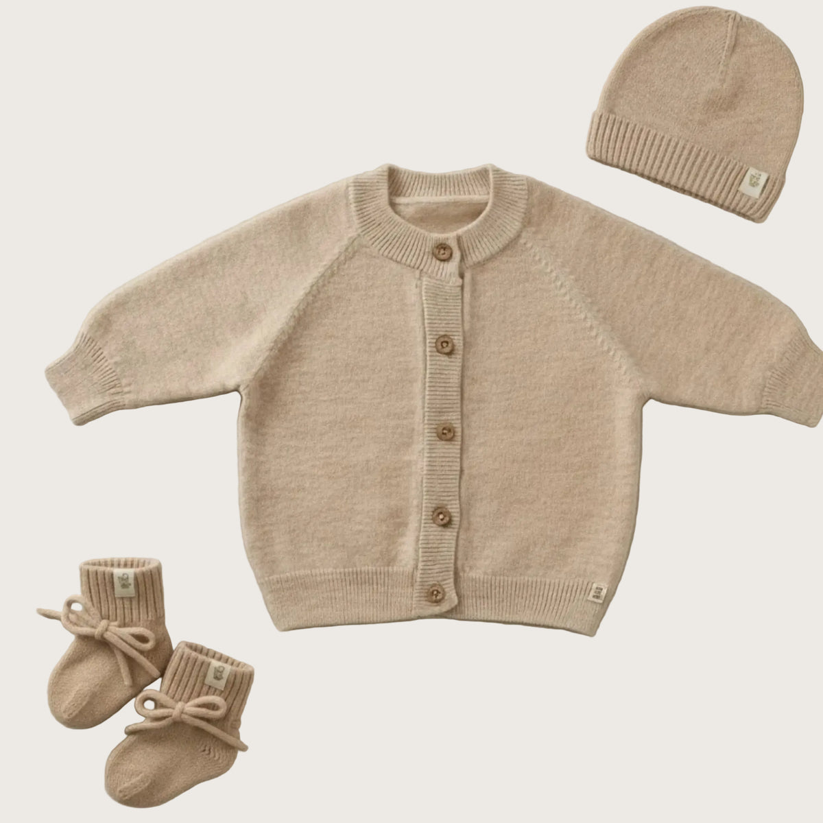 Baby gift set in beige merinowool. The set contains a beanie, cardigan and booties. 