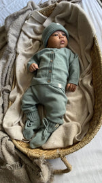 Baby in sage groene Moalie outfit van merinowol en cashmere