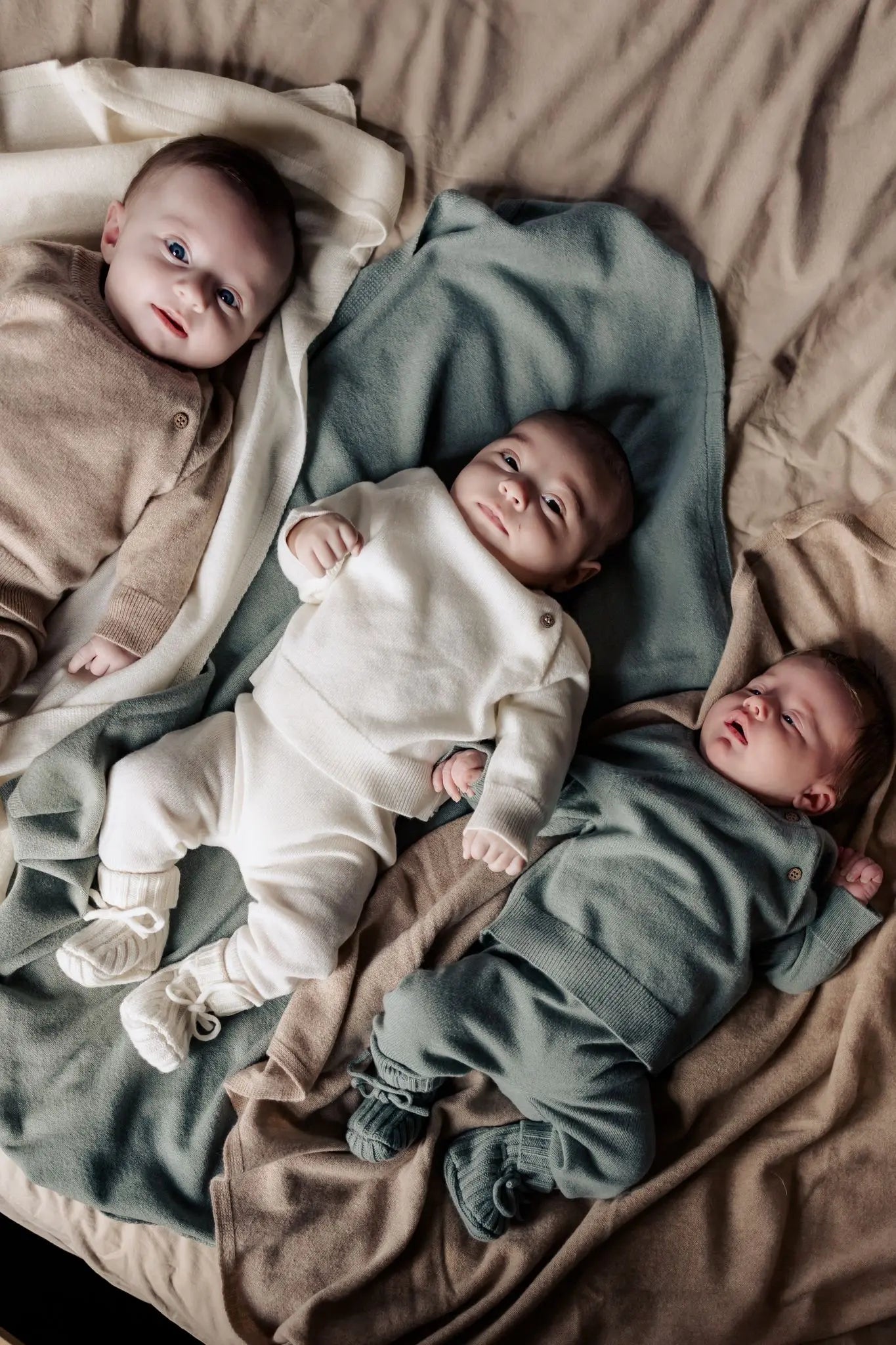drie baby's in wollen Moalie outfit in beige, creme en sage kleur 