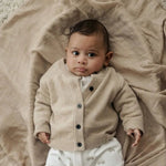 baby in beige vestje van merinowol