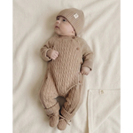 Baby in beige boxpakje van merinowol en cashmere op wollen creme kleurige deken