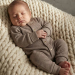 slapende baby inBoxpakje van bruin gebreide stof 