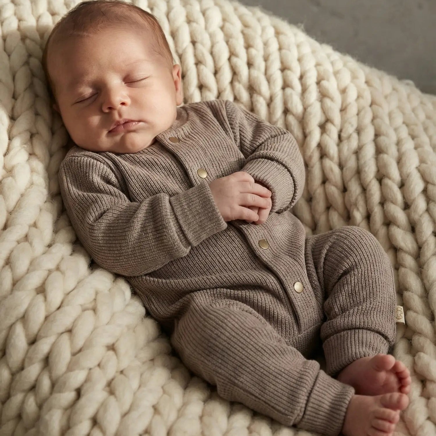 slapende baby inBoxpakje van bruin gebreide stof 