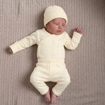 Pasgeboren baby in  geboortepakje en katoenen babymuts in Buttercup Yellow