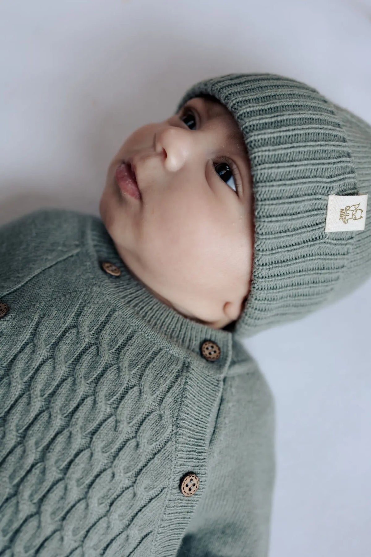 Baby in boxpakje en muts van sage groene merinowol en cashmere 