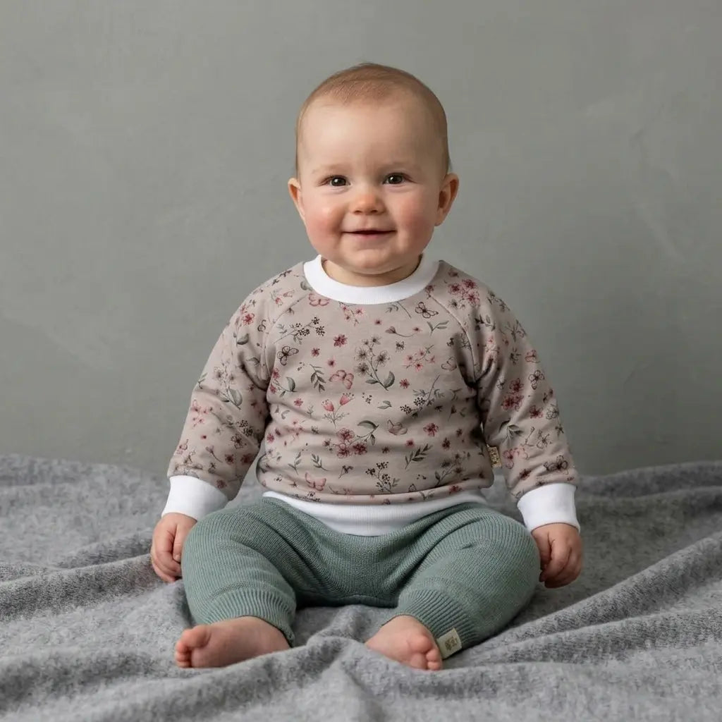baby in gebloemde sweater en wollen sage groene broekje 