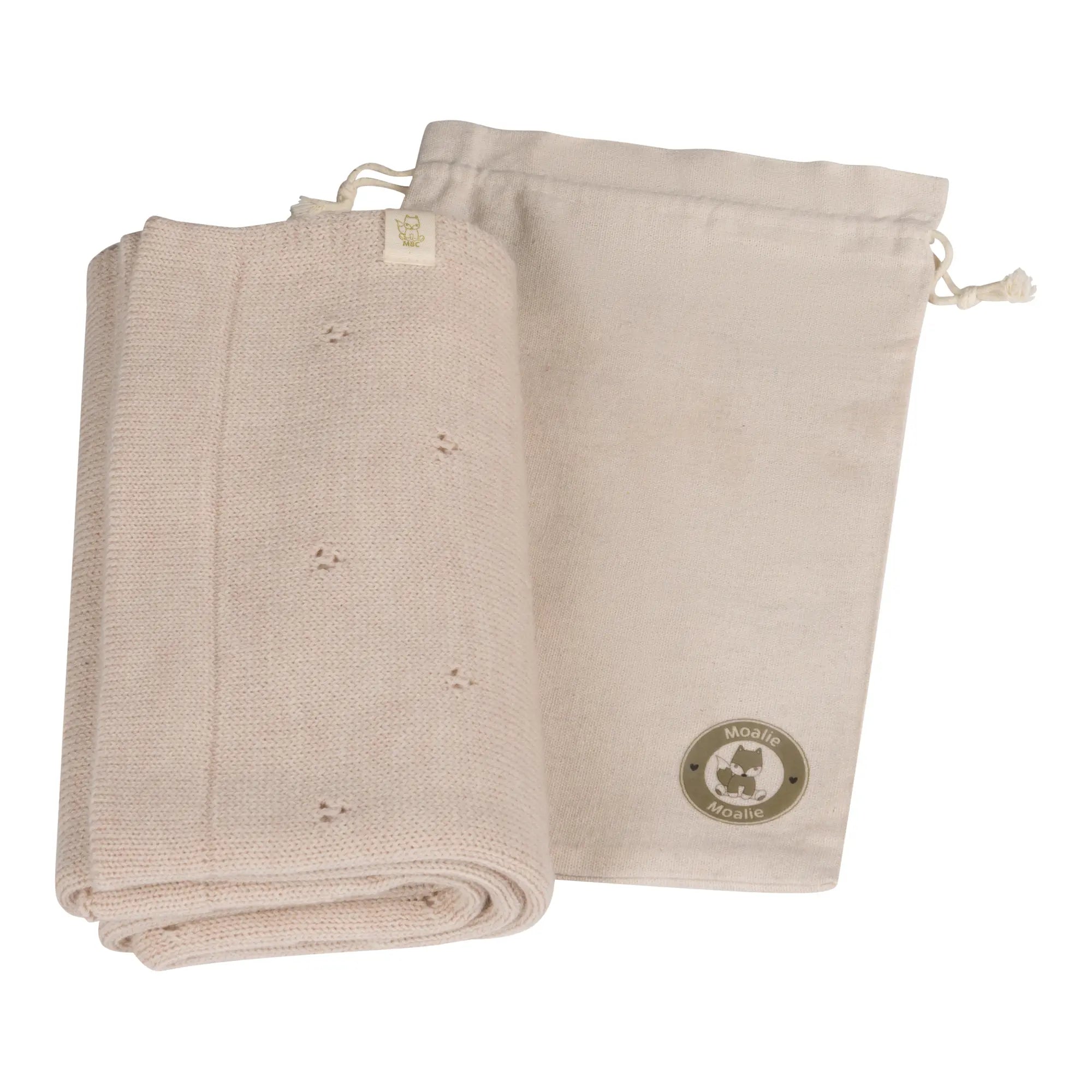opgevouwen beige wollen pointelle deken met opbergzak 