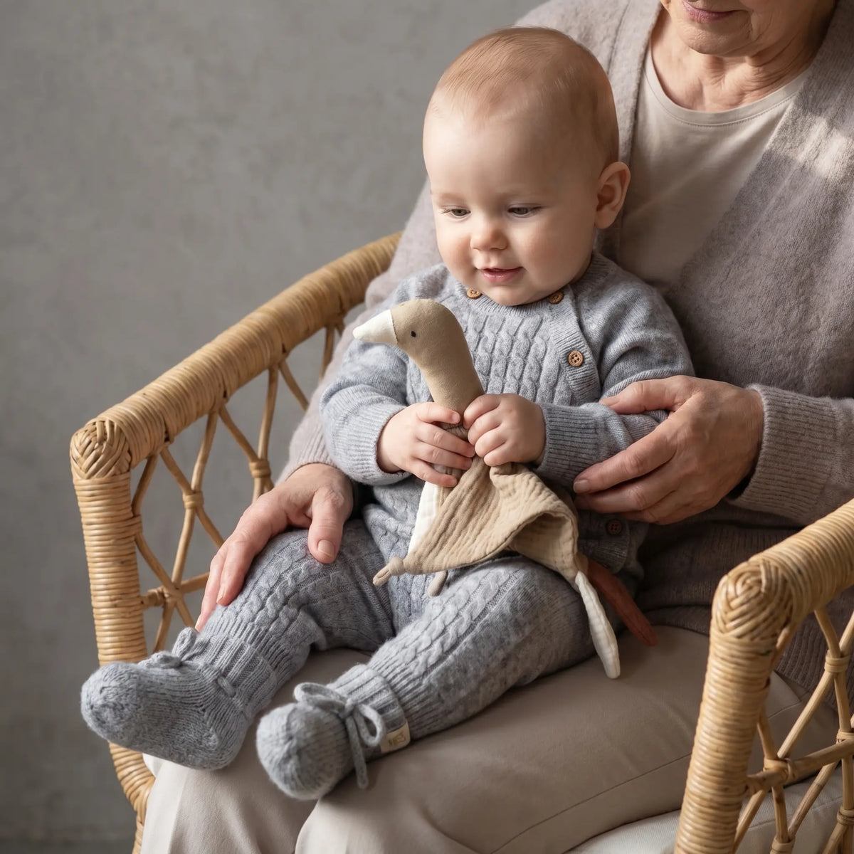 baby in Grijs_boxpakje_merinowol_en_cashmere_met_grijze_slofjes bij oma op schoot