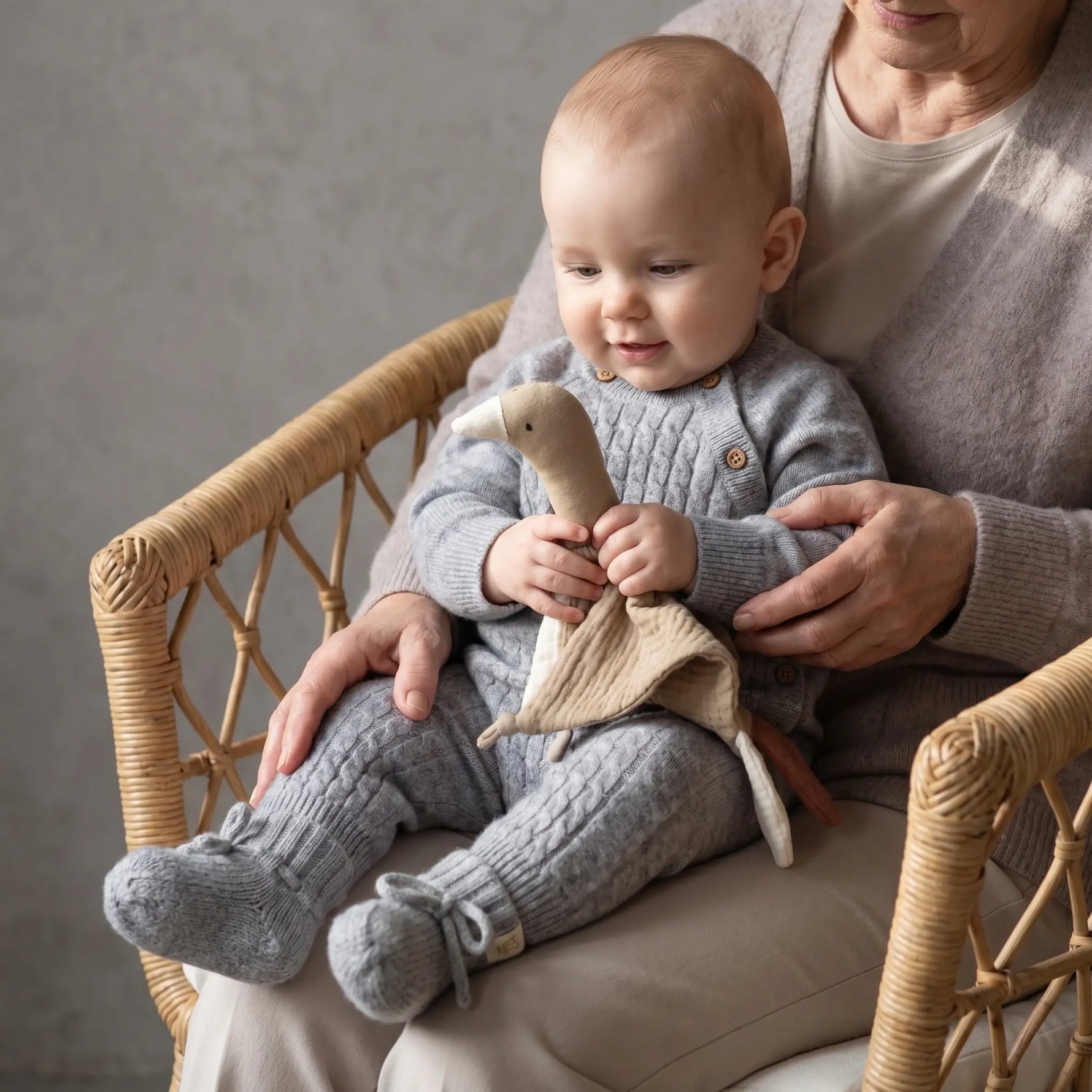 baby in Grijs_boxpakje_merinowol_en_cashmere_met_grijze_slofjes bij oma op schoot