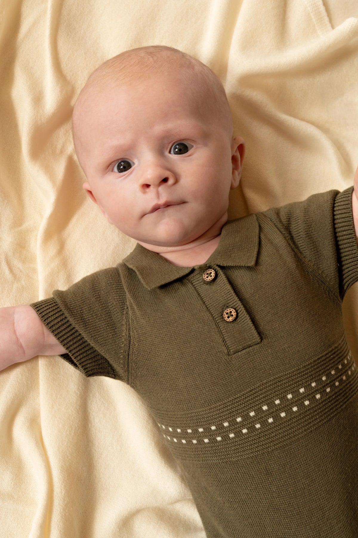 close up van baby in Groen zomer boxpakje met polokraagje 