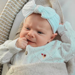 baby met witte elastische haarband met strik. 