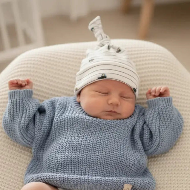 baby in denim blauwe trui en mutsje met voertuigen 