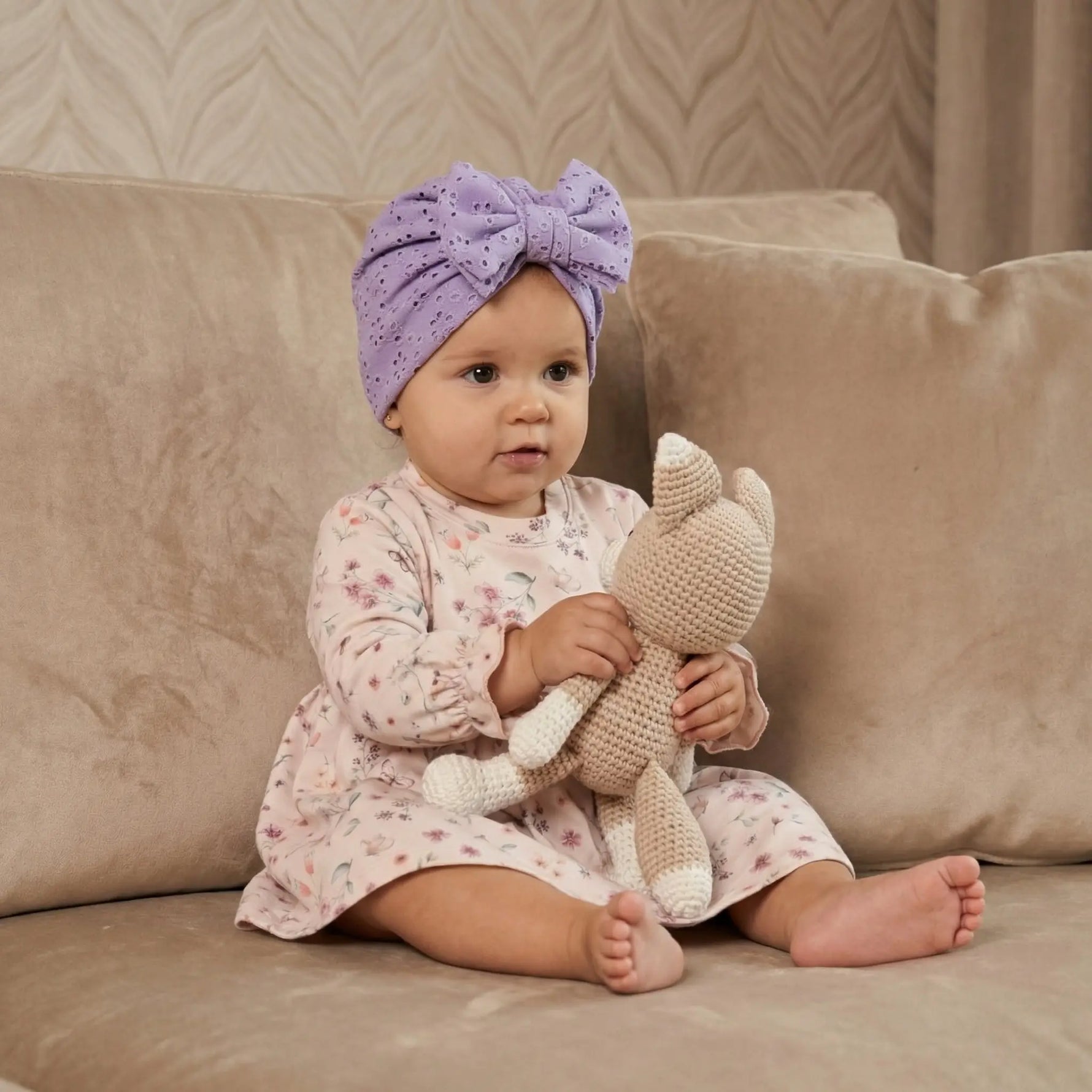 baby in gebloemd jurkjeLila baby mutsje van broderie stretch katoen 