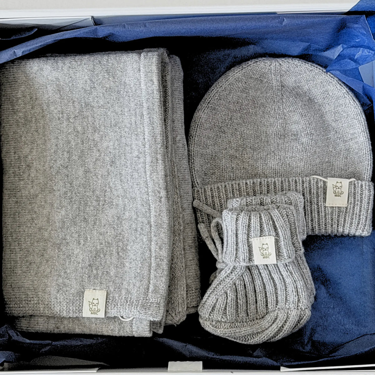 Newborn giftset bestaande uit wikkeldeken, muts en slofjes van grijze merinowol en cashmere blend in luxe bewaardoos