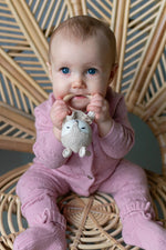 baby op rotan stoel gekleed in een Merinowol/cashmere boxpakje en slofjes roze 