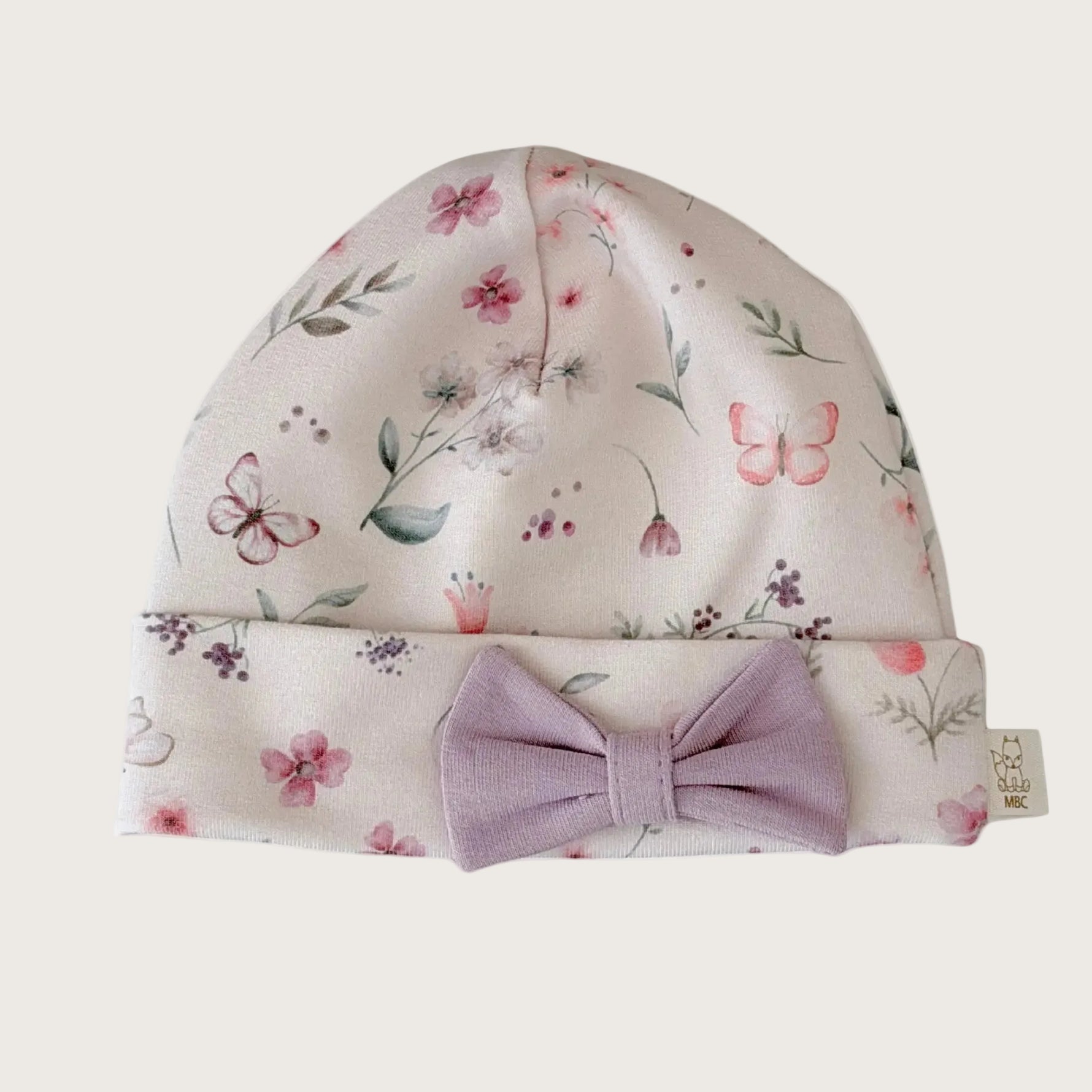 Newborn mutsje met bloemen en vlinder print en lila strikje 