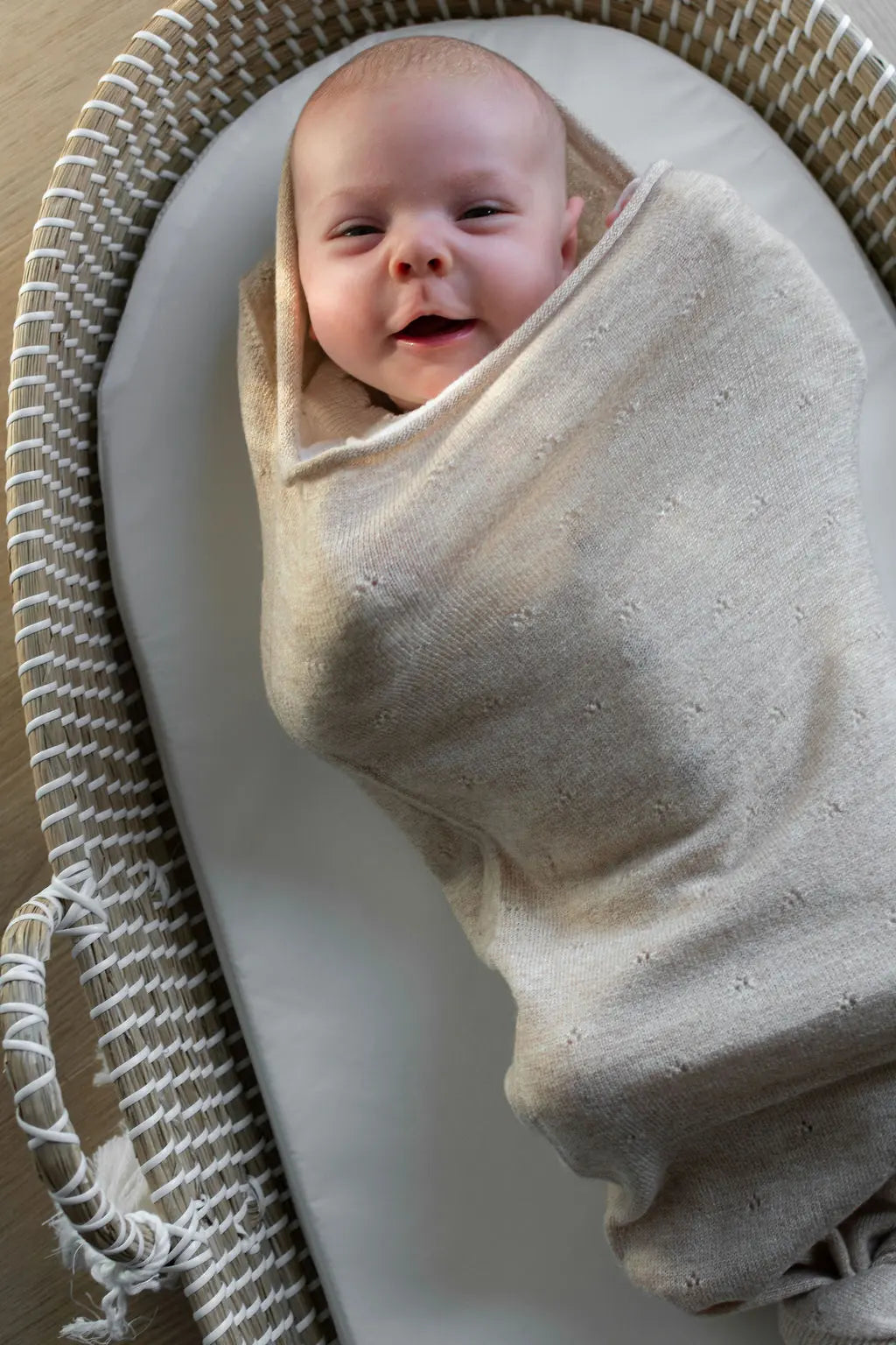 lachende baby in Snuggle van merinowol in Pointelle beige 