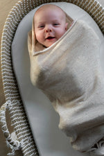 lachende baby in Snuggle van merinowol in Pointelle beige 