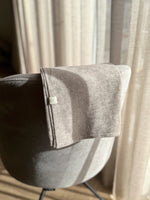 Wollen 3 in 1 deken Sand hangend over eetkamerstoel 