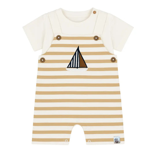 Zweiteiliges Outfit für Babys und Kleinkinder, bestehend aus einem weißen T-Shirt und einer weiß/beige gestreiften Latzhose mit Holzknöpfen und Segelboot-Applikation. Erhältlich von Größe 68 bis 98/104, mit Druckknöpfen zwischen den Beinen für die kleinsten Größen.