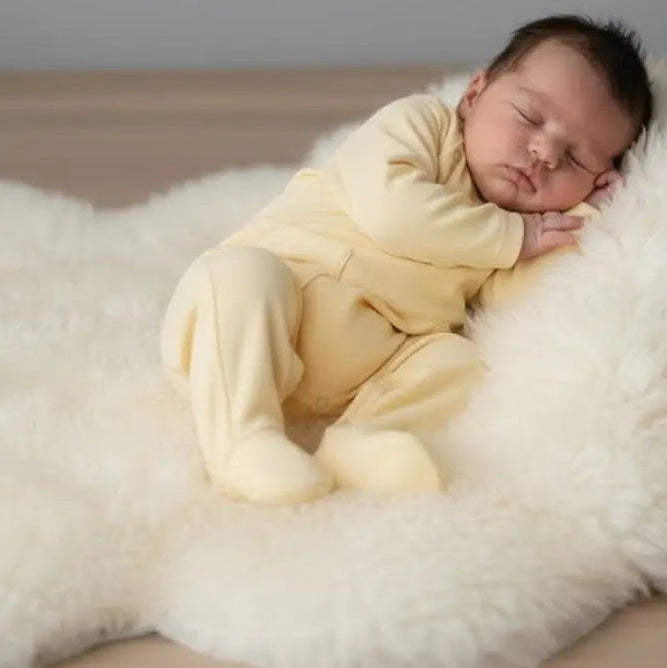 slapende baby in boxpakje zacht geel 
