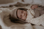 slapende baby in cocon van wol, camelkleur 