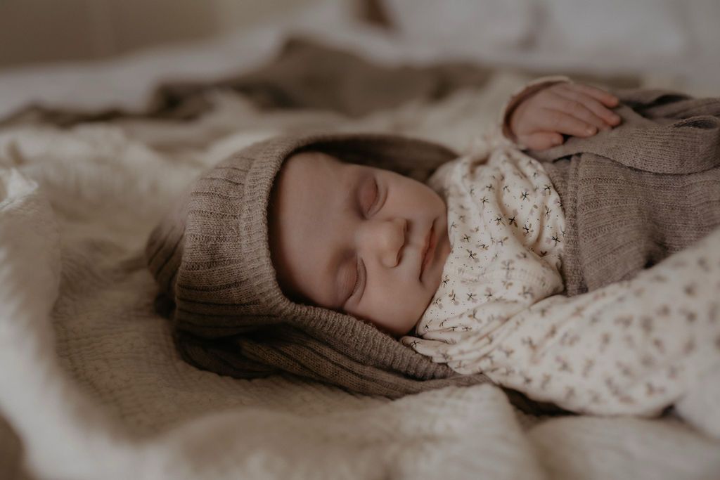 slapende baby in cocon van wol, camelkleur 