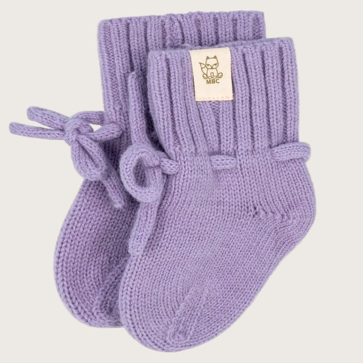 Merinowollen babyslofjes in lila (Lavender) met strikkoordjes, op een witte achtergrond
