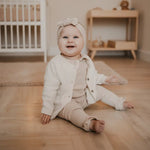 baby in creme kleurig vestje van merinowol en cashmere 
