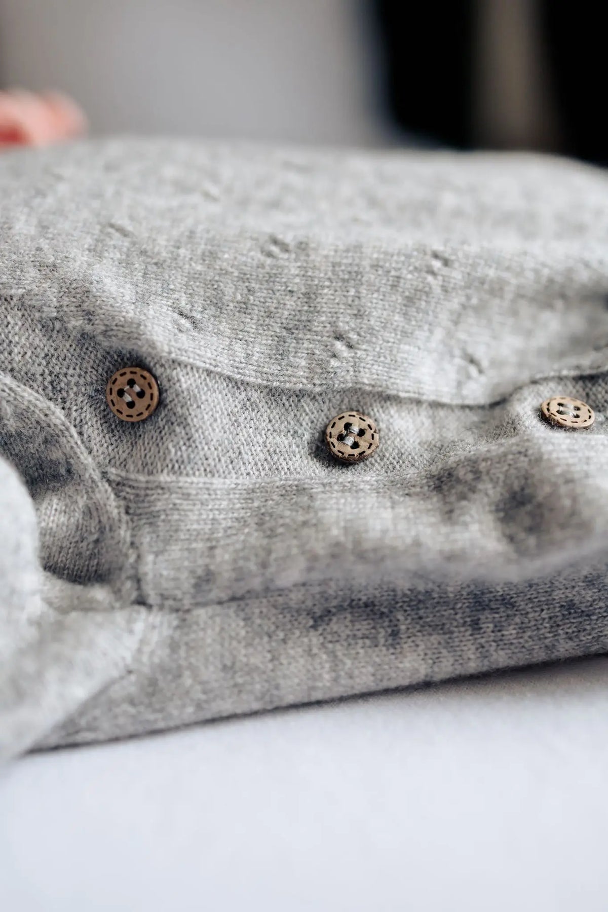 houten knoopjes op grijs boxpakje van merinowol en cashmere