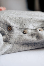 houten knoopjes op grijs boxpakje van merinowol en cashmere