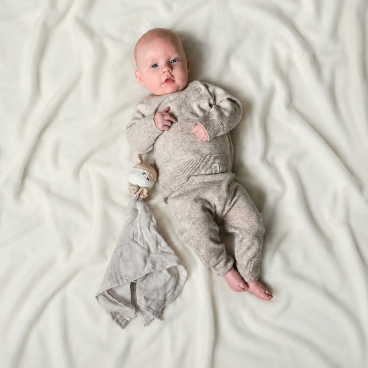 newborn dressed in merinowool and cashmere outfit in beige sand color