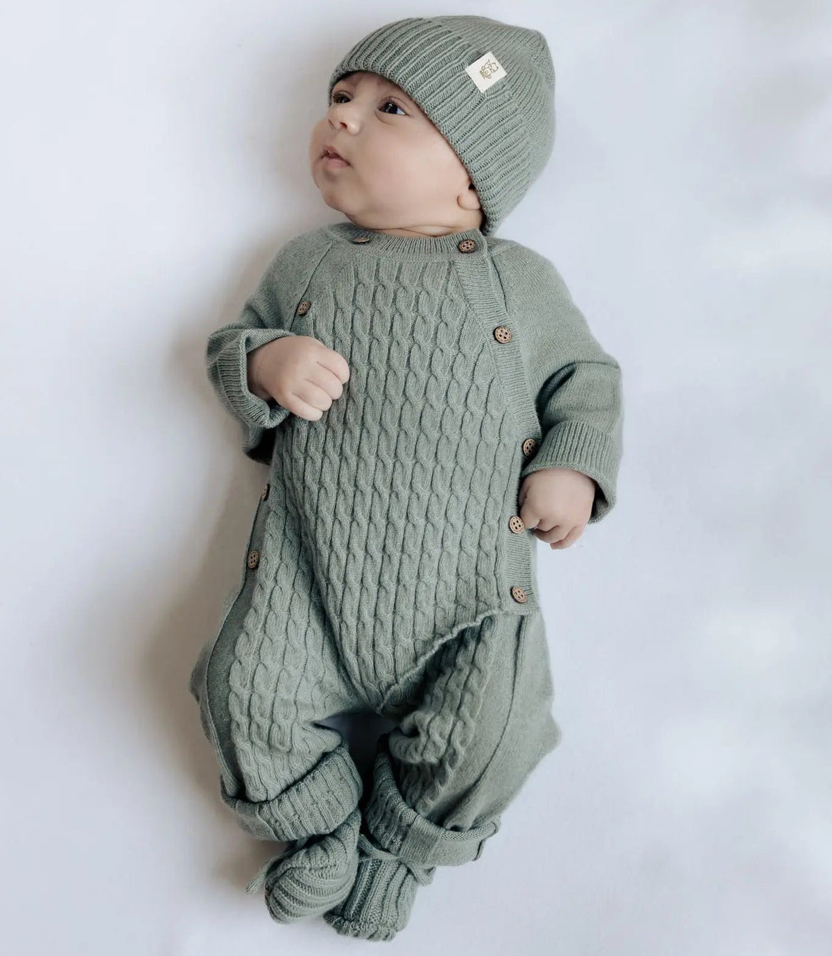 baby in kabelgebreid wollen boxpakje en wollen must in sage groene kleur 