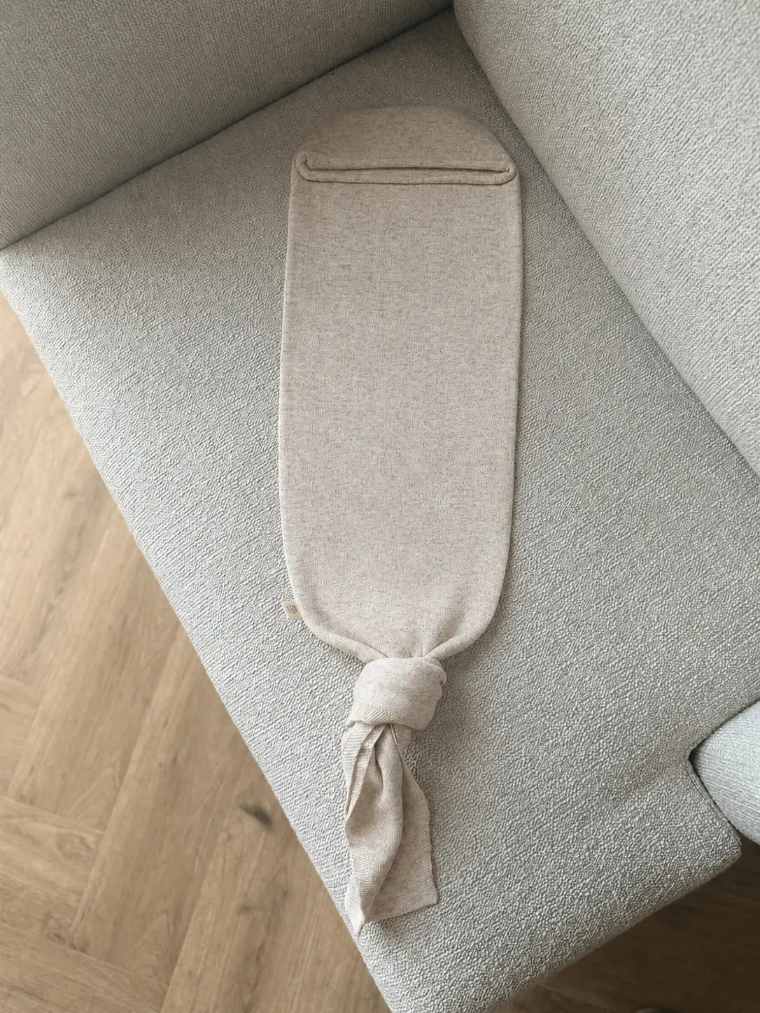 merinowol en cashmere baby cocoon Sand op stole in woonkamer met visgraatvloer 