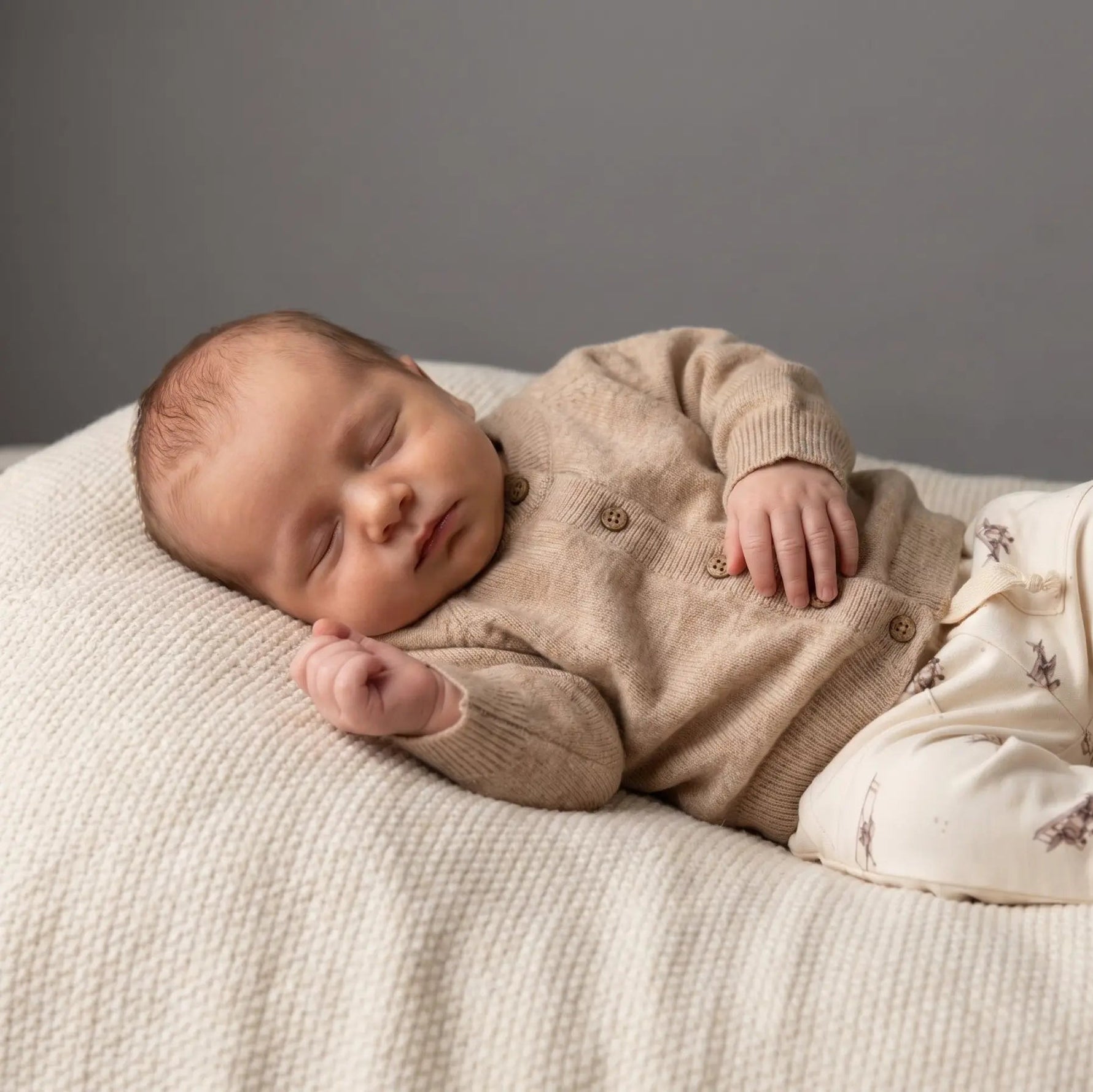 slapende baby in merinowollen beige vestje 