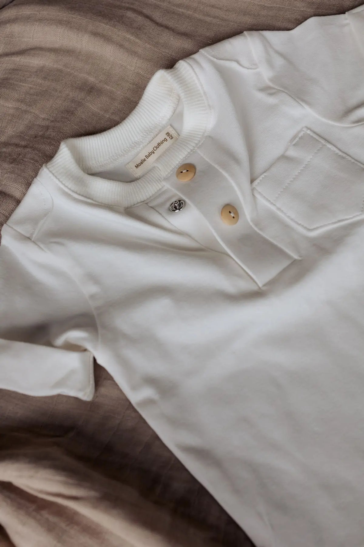 Detail verborgen drukknoopjes en houten sierknoopjes T-Shirt Miles – handgemaakt baby t-shirt Moalie