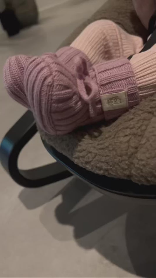 Babyvoetjes in video dragen newborn slofjes merinowol oud roze 
