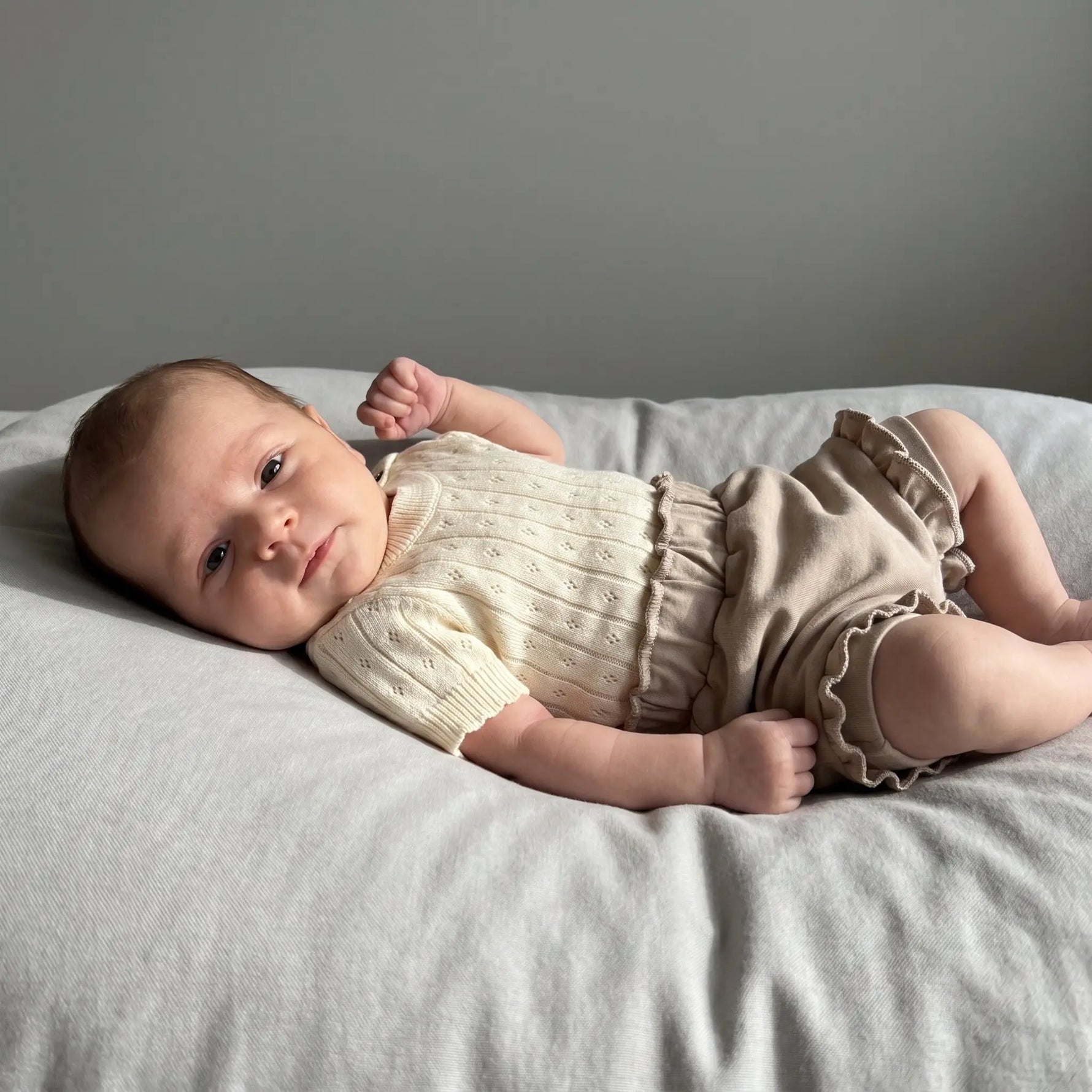 baby in taupe kleur french terry baby bloomers en gebreide katoenen romper in creme kleur 